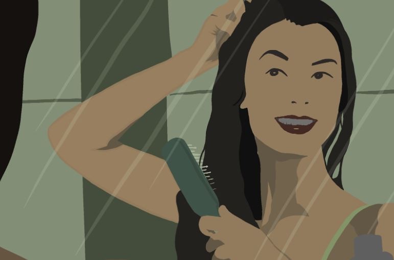 a woman in front of a mirror combing and fixing her beautiful hair